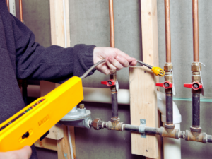 plumber using gas line leak detector to see if gas lines are failing 