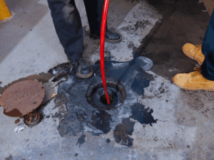 plumbers feeding hydro jet line down sewer cleanout