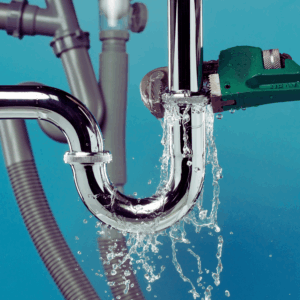 Plumber using monkey wrench to fix plumbing leak