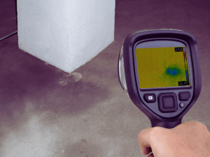 plumber using thermal imaging to find underground water leak